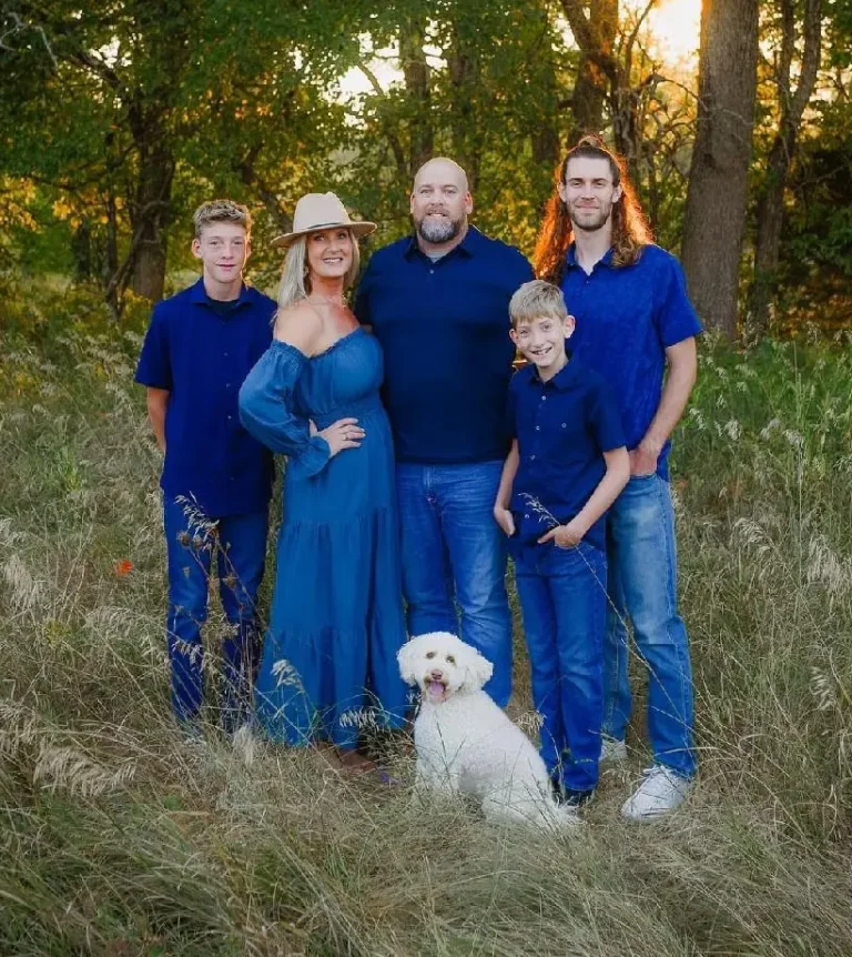 A photo of a family including their dog standing in a field